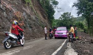 Petugas melakukan pengaturan dijalan yang tertimbun longsor